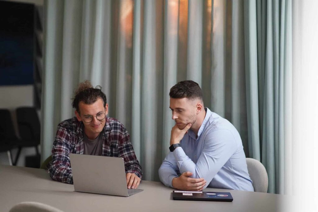 Zwei Mitarbeiter von wiwamedia arbeiten gemeinsam am Laptop