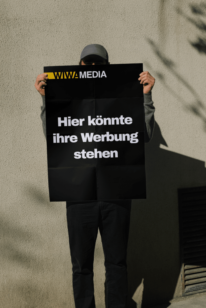 Person hält ein Plakat mit der Aufschrift Hier könnte Ihre Werbung stehen